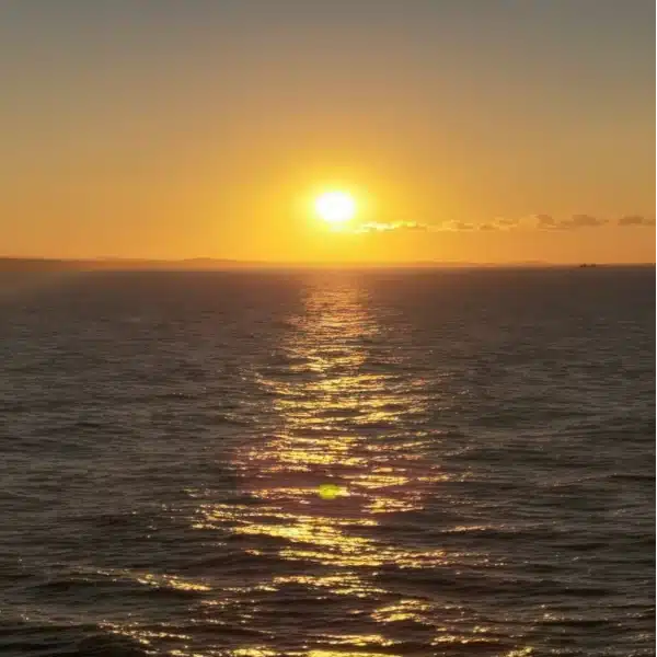 Trattamento benessere degli Dei: foto di un tramonto rigenerante sul mare con riflessi dorati sull'acqua